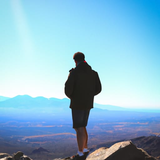 A person standing on a mountain top, looking out at the horizon symbolizing a clear vision of the future